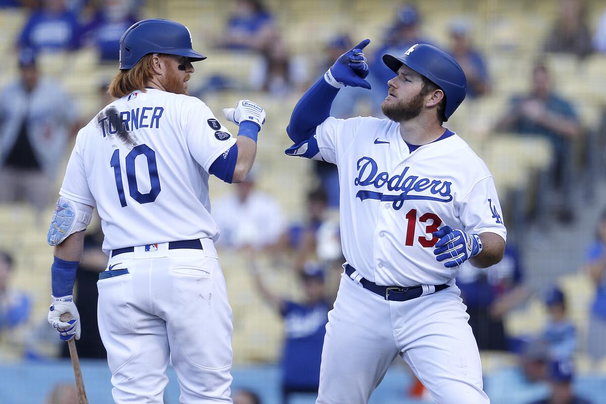 Dodgers third baseman Justin Turner, left, congratulates Dodgers second baseman Max Muncy.