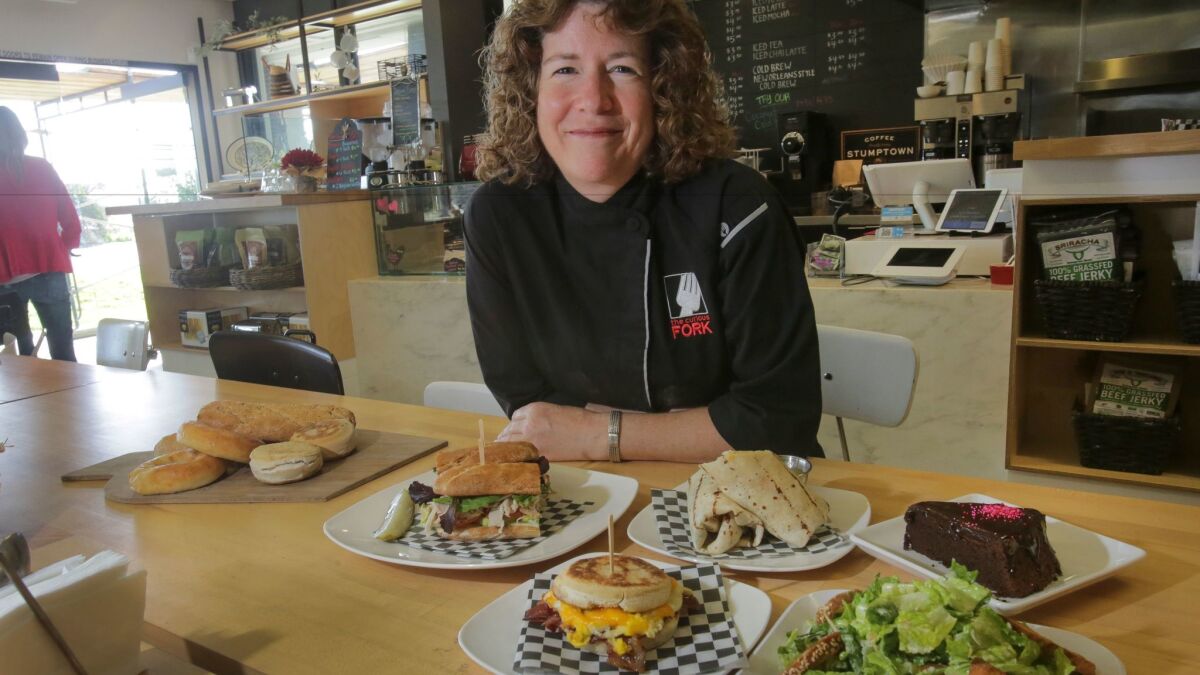Barbara McQuiston, founder and owner of The Curious Fork cafe, bakery and cooking school in Solana Beach, with some of her gluten-free sandwiches, wraps, breads and desserts.