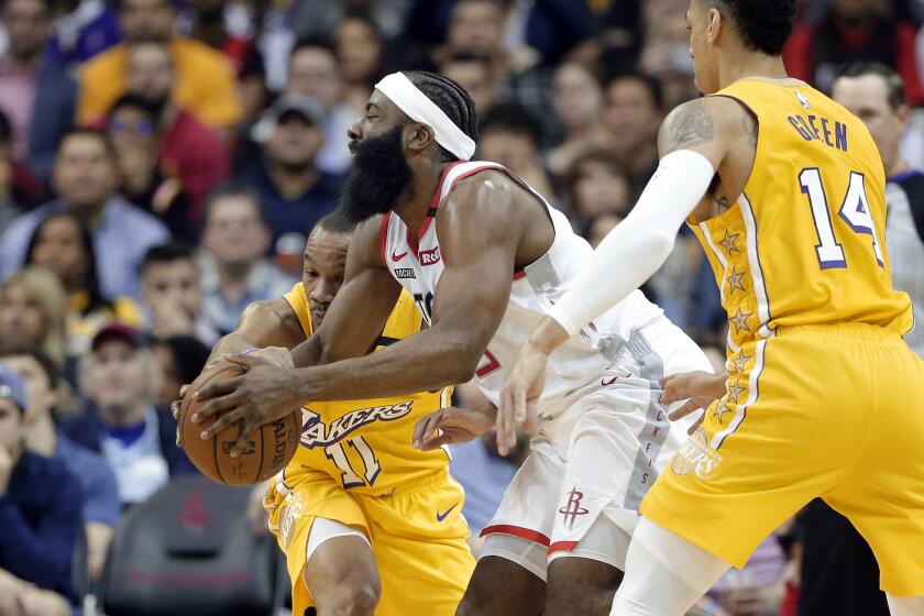 Rockets guard James Harden, center, tries to split the defense of Lakers guards Avery Bradley, left, and Danny Green during the first half of a game Jan. 18, 2020, in Houston.