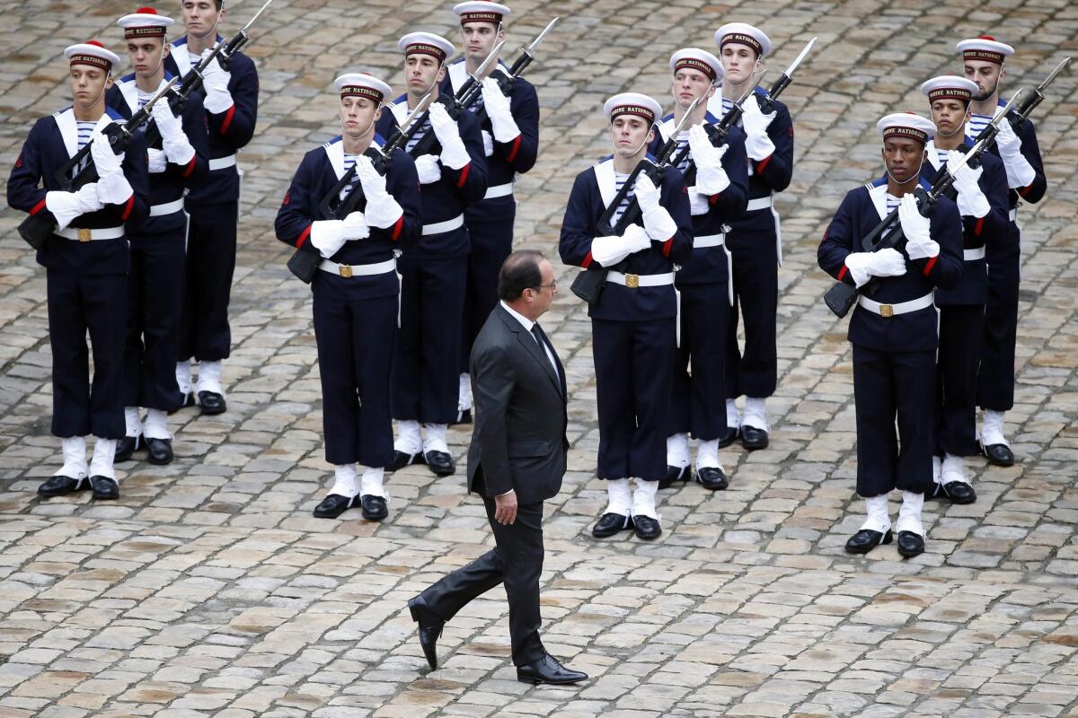 French President Francois Hollande reviews French troops during a military ceremony at the Military Hotel National des Invalides, in Paris, on Nov. 19.