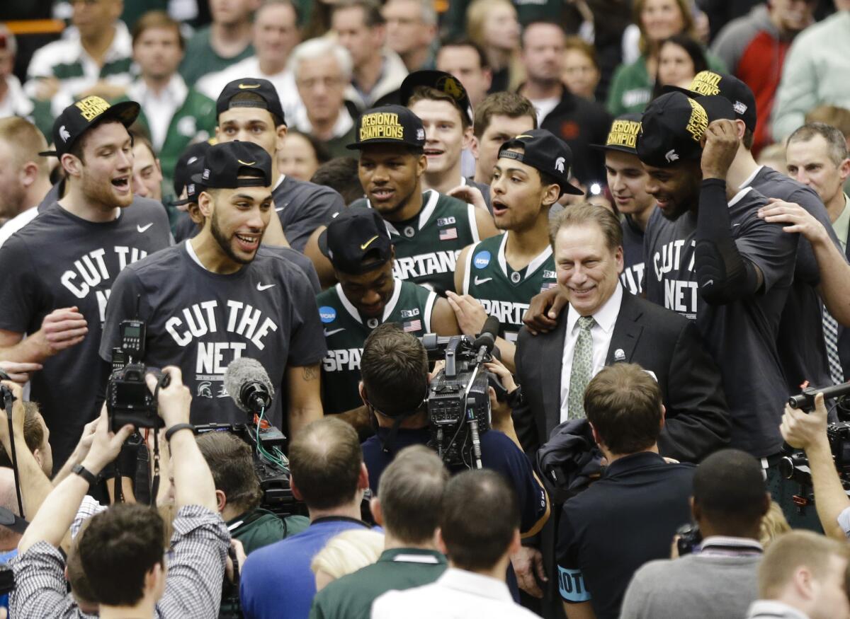 Michigan State Coach Tom Izzo celebrates with his team after the East Regional final against Louisville on Sunday.