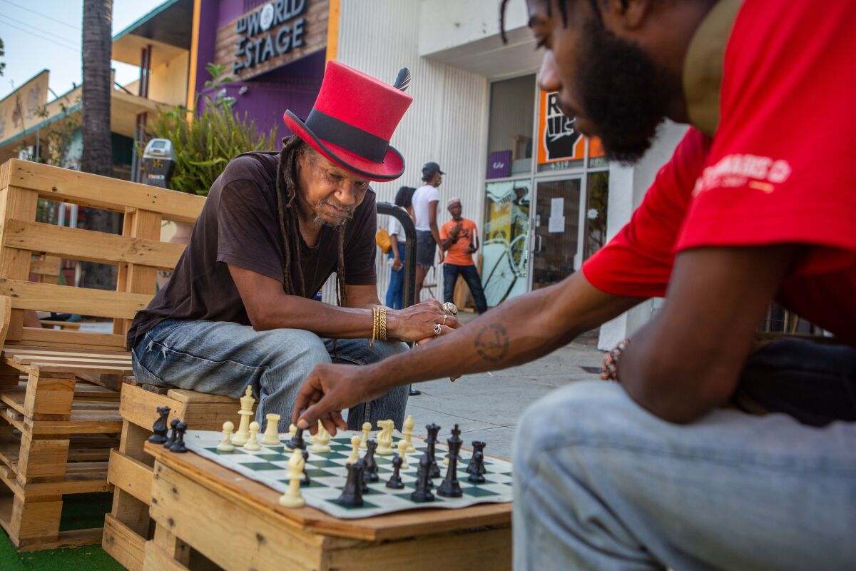 Two men play chess in Leimert Park while enduring a heat wave sweeping through the Southland.