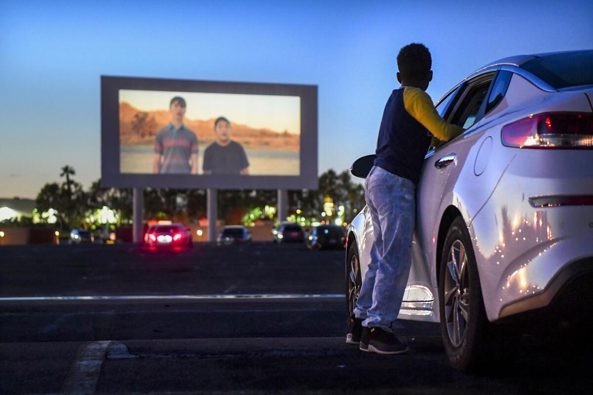 PARAMOUNT, CALIFORNIA MARCH 17, 2020-Michael Ray, 11, watches a trailer before a movie at the Paramount Drive-In. (Wally Skalij/Los Angeles Times)