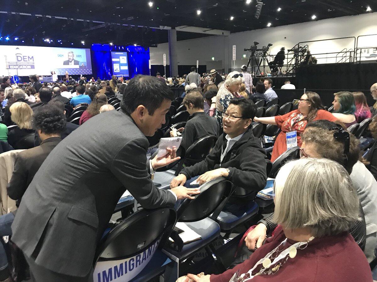 Dave Min, left, lobbies California Democratic Party delegates on the convention floor, asking them to support his endorsement.