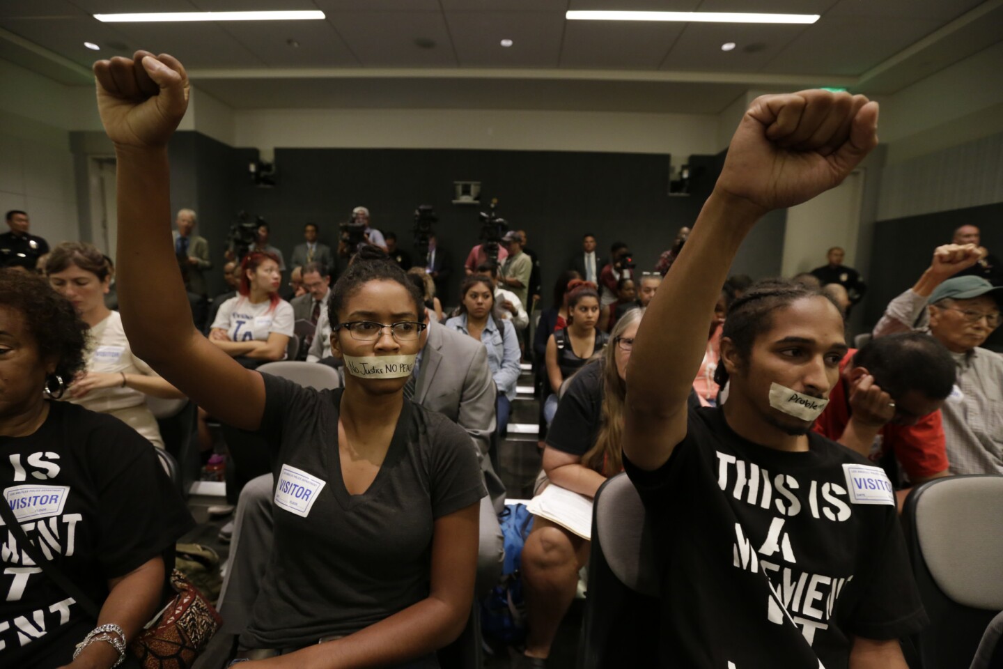 From left, Nia-Amina Minor and Terue Williams participate in a silent protest at the weekly Los Angeles Board of Police Commissioners meeting.