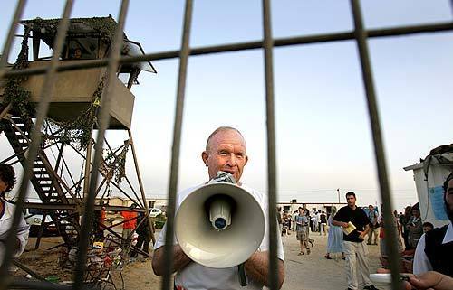 Arieh Yitshaki talks to followers on a bullhorn at the gates of the Jewish settlement of Shirat HaYam as they wait anxiously for the Israeli Defense Forces to arrive, bringing their order to vacate the Gaza land they have occupied for decades. Yikshaki has advocated violence to keep the settlers' hold on the occupied Gaza land.