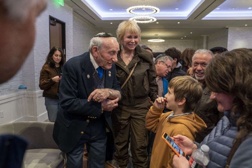 Newport Beach, CA - January 29: Holocaust survivor Joseph Alexander, left, shows Isaac Pais, 11, the tattoo on his arm that was put on him when he was sent to a concentration camp after the Nazis invaded Poland. Alexander speaks at the Chabad Center for Jewish Life of Newport Beach on Sunday, Jan. 29, 2023. (Scott Smeltzer / Daily Pilot)