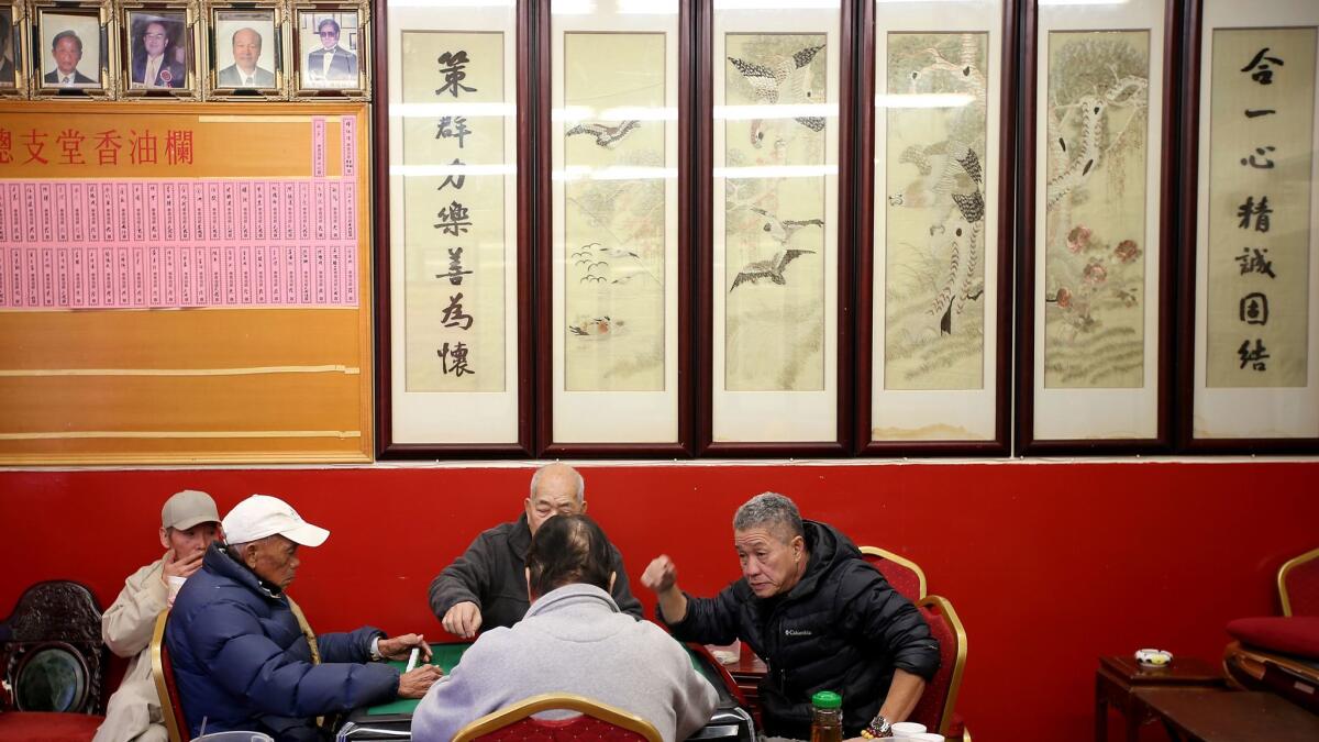 A group of men play mah-jongg at the Hop Sing Tong Benevolent Assn., a day after two men were fatally stabbed at the Chinatown club.