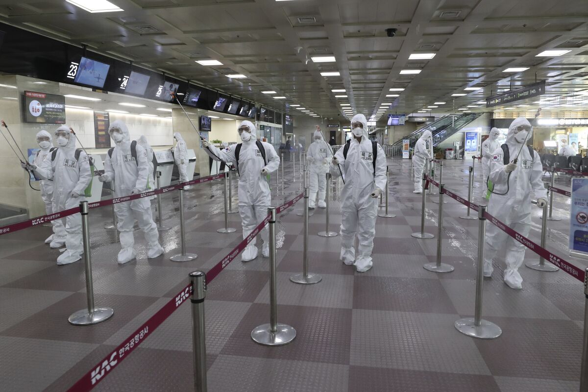 South Korean army soldiers wearing protective suits spray disinfectant to prevent the spread of the new coronavirus at Daegu International Airport.