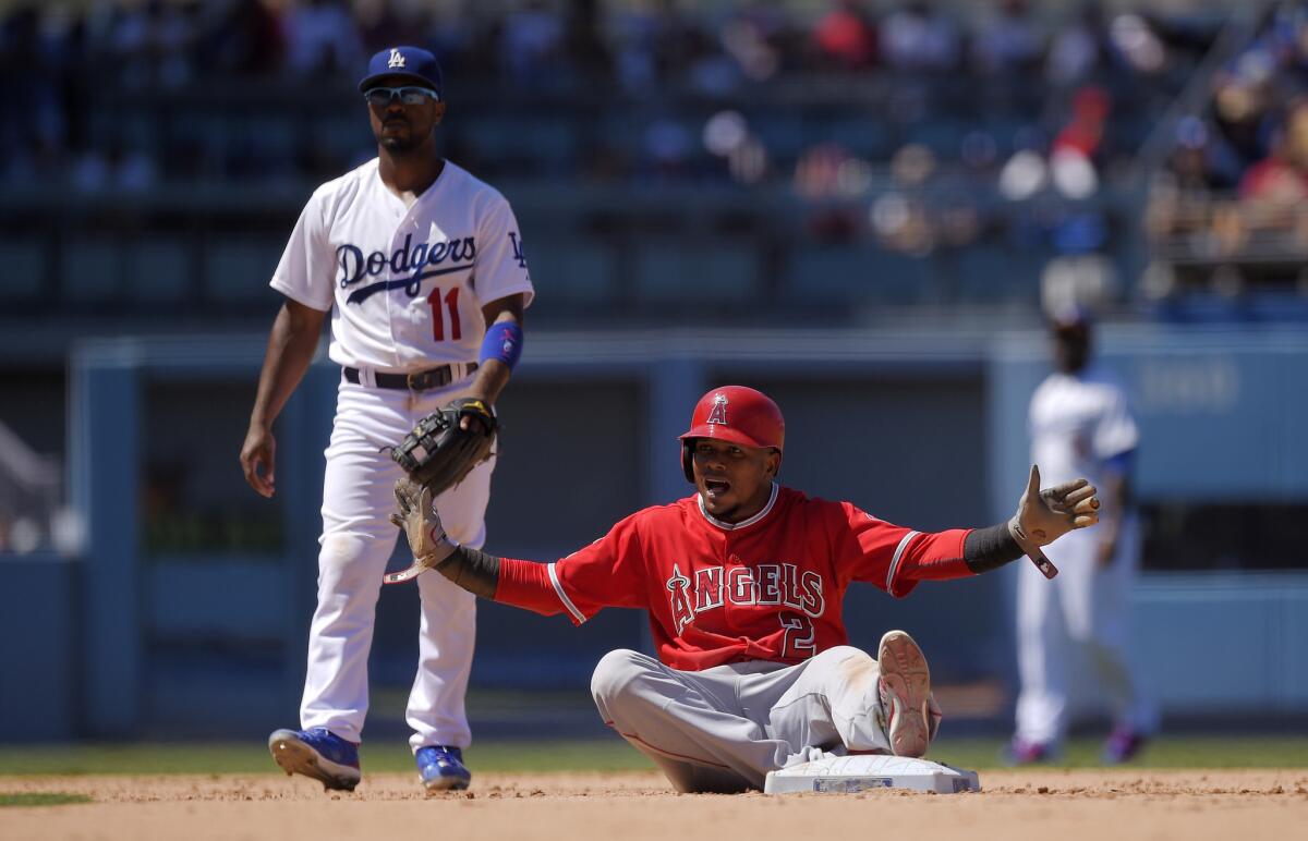 Angels shortstop Erick Aybar gestures after advancing to second on a groundout as Dodgers shortstop Jimmy Rollins looks on.