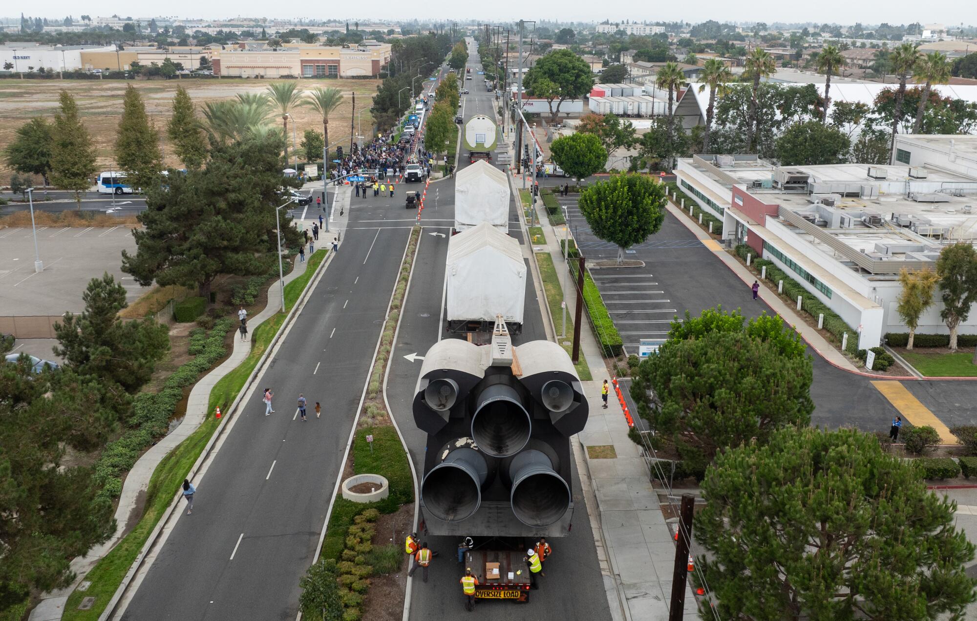 Vista aérea de un modelo de nave espacial que transporta carga por una calle de la ciudad.