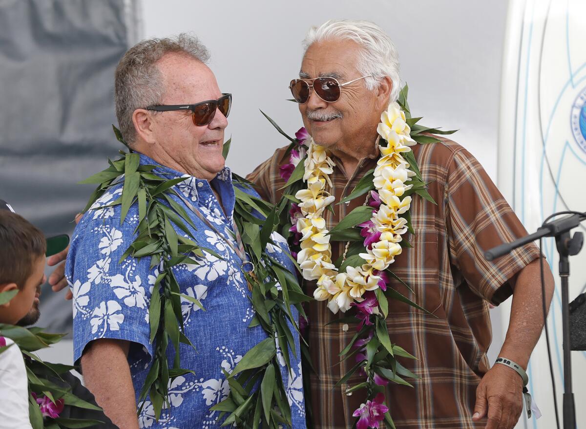Robert "Chuy" Madrigal, right, greets Peter "PT" Townend during the Surfing Walk of Fame induction ceremony.