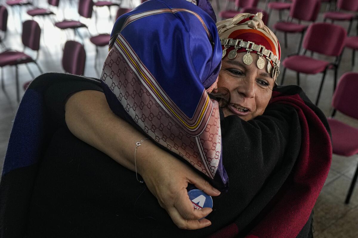 La indígena mapuche María Valdivia Calfuquir, a la derecha, abraza a Ximena Cumican 