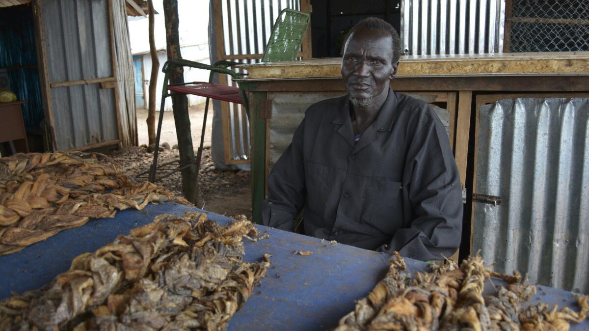 John Gai, 58, at his shop in a displaced persons camp in South Sudan, where he sells braided dried fish and other food supplies.