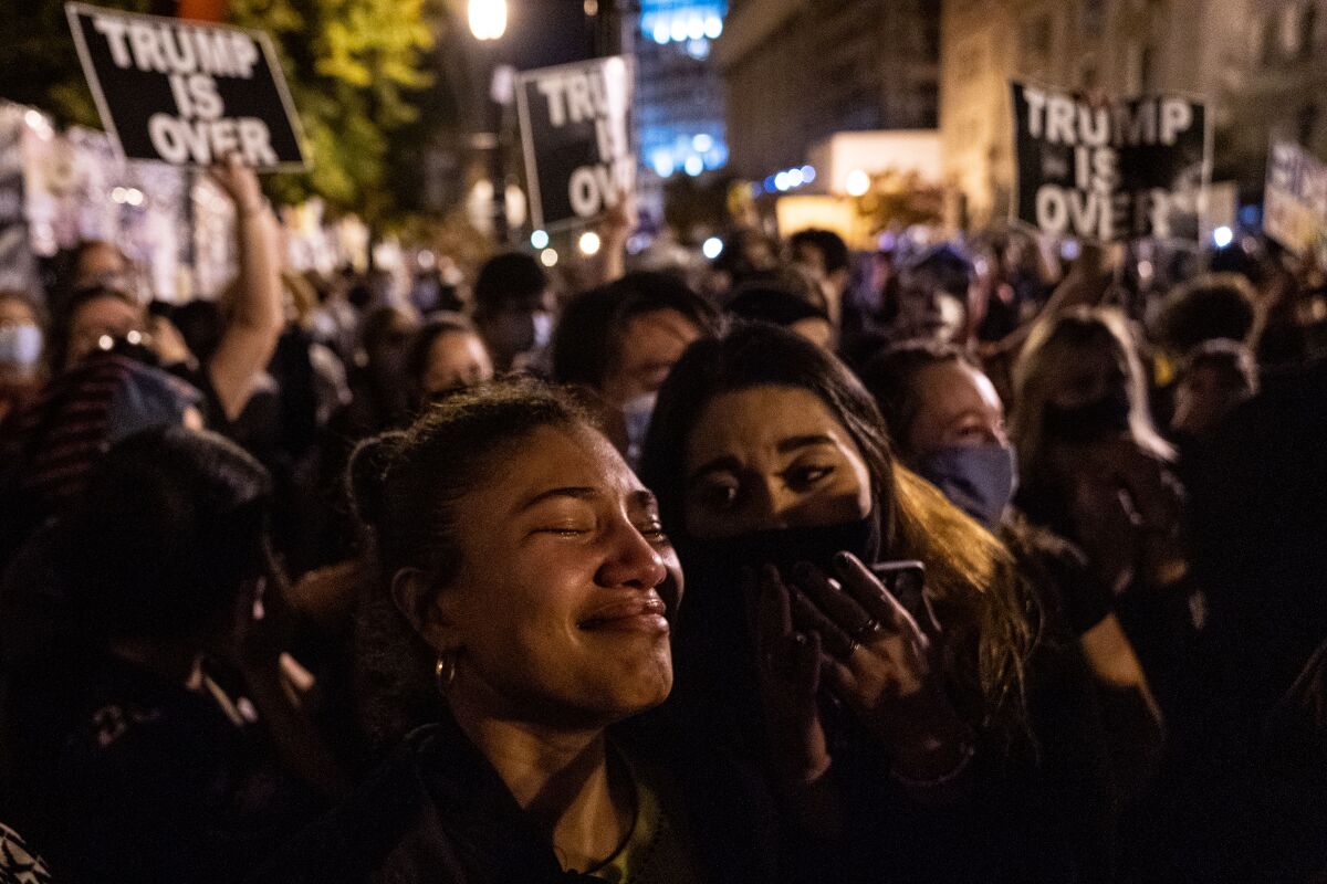 A crowd at Black Lives Matter Plaza in Washington reacts to Joe Biden's victory speech on Nov. 7. Signs read "Trump is over."