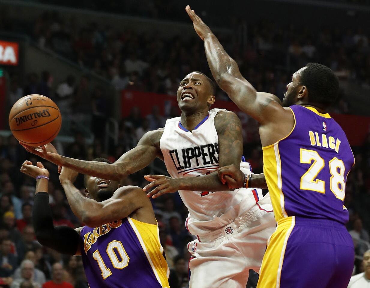 Clippers guard Jamal Crawford drives to the basket in between Lakers guard David Nwaba, left, and center Tarik Black, right, during the first half of a game on April 1 at Staples Center.