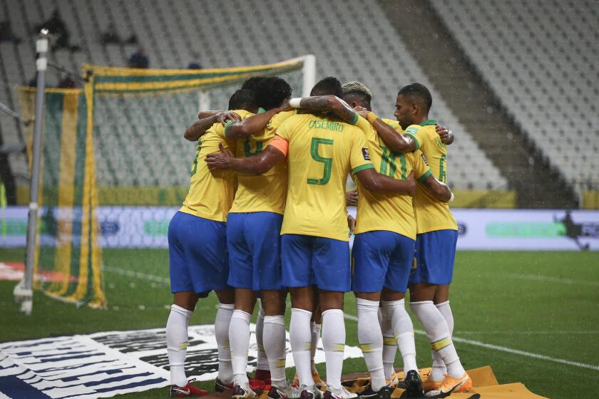 Players of Brazil celebrate their side's opening goal scored by teammate Marquinhos during a qualifying soccer match for the FIFA World Cup Qatar 2022 against Boliviaat the Neo Quimica arena in Sao Paulo, Brazil, Friday, Oct. 9, 2020. (Buda Mendes/Pool via AP)