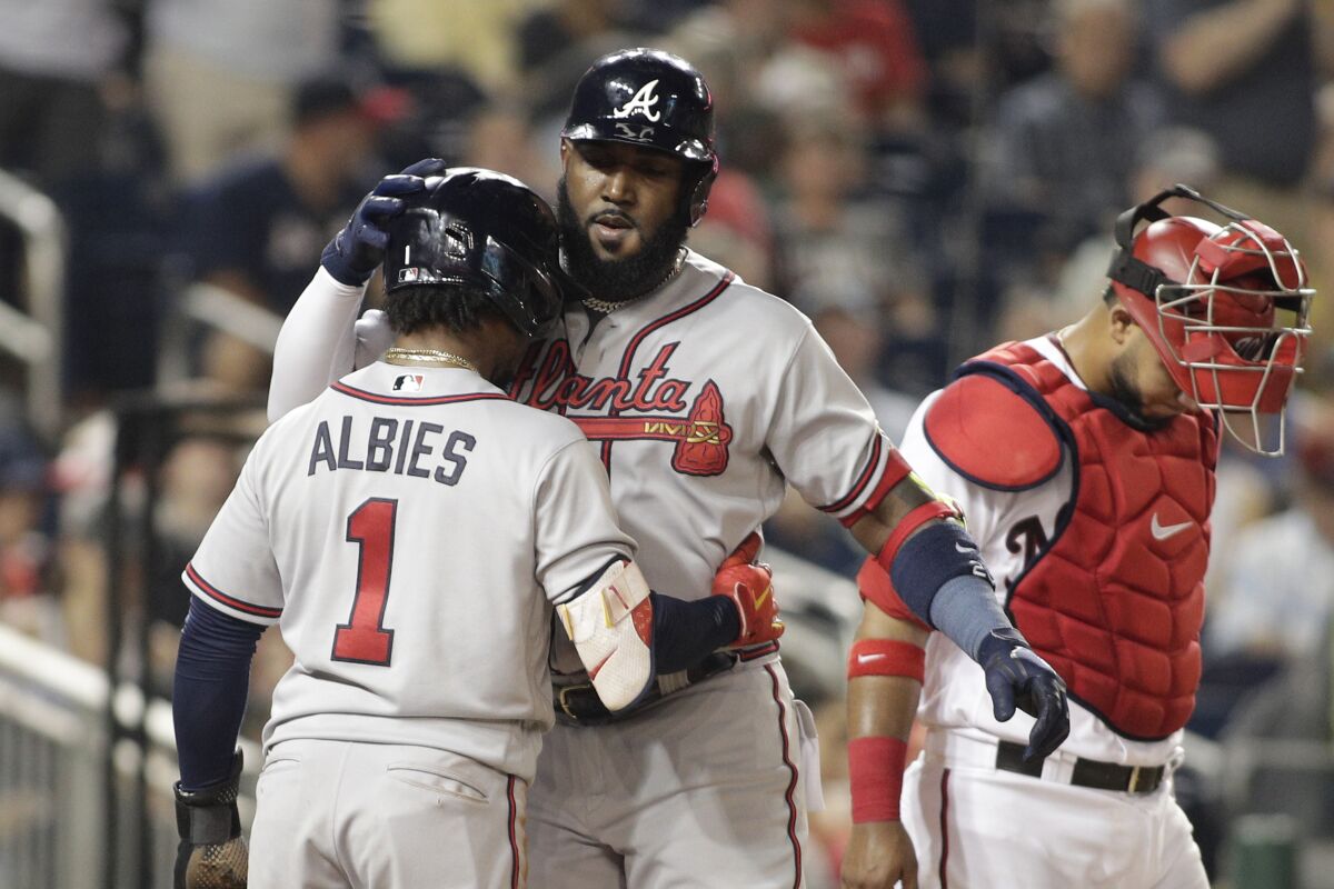 Atlanta Braves' Marcell Ozuna, right, celebrates with teammate Ozzie Albies (1) after hitting a two-run home run during the third inning of a baseball game against the Washington Nationals, Monday, June 13, 2022, in Washington. (AP Photo/Luis M. Alvarez)