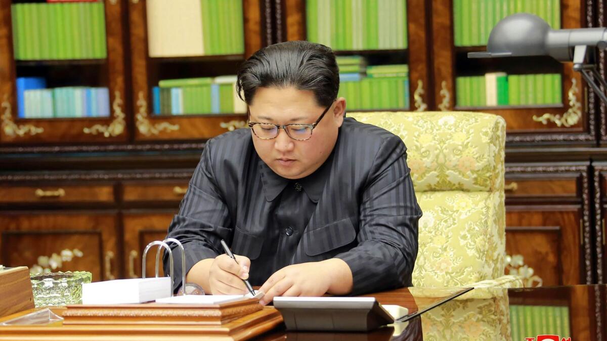 North Korean leader Kim Jong Un signs a document ordering the test-firing of the intercontinental ballistic missile Hwasong-15 on Nov. 28, 2017, in an image from North Korea's official Korean Central News Agency .