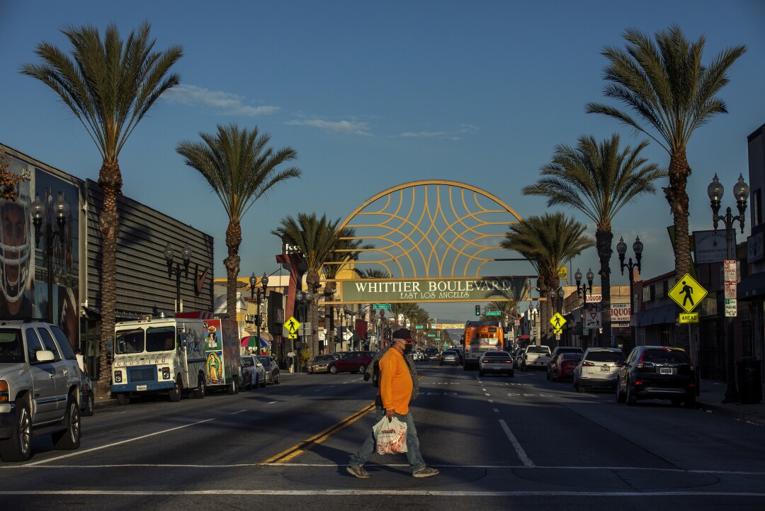 A pedestrian crosses Whittier Blvd in East Los Angeles.