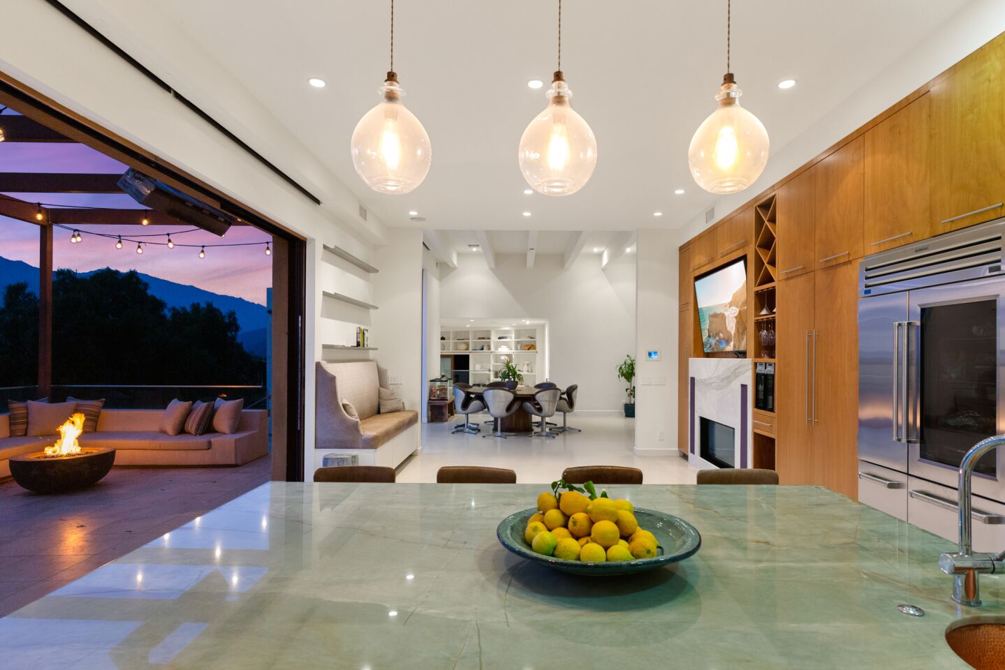 Lights hang over a polished concrete island in the kitchen which opens to the deck.