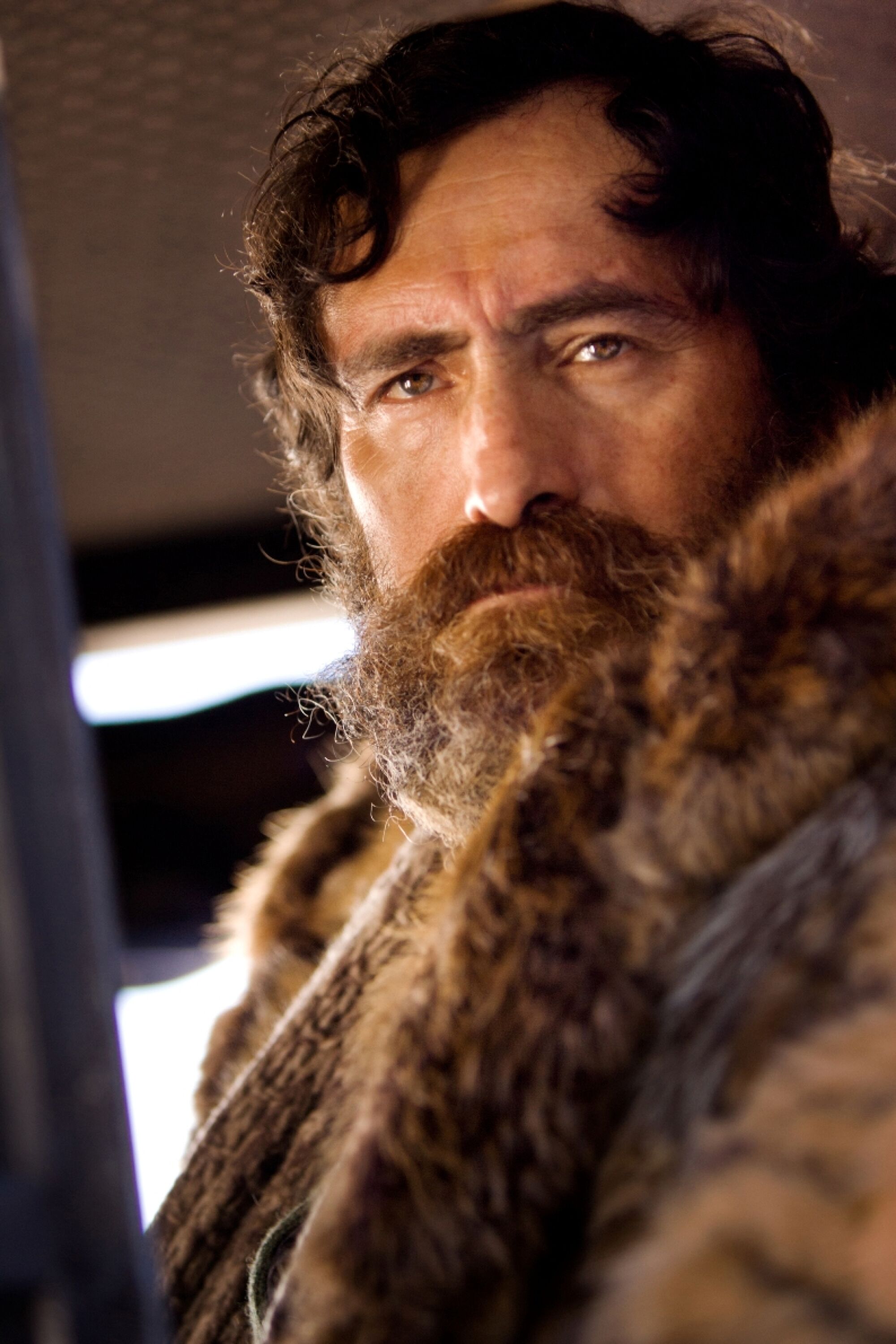 Demián Bichir in full beard, wearing a fur coat, in "The Hateful Eight."