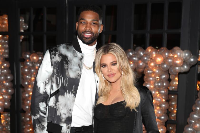 Tristan Thompson and Khloe Kardashian pose for a photo at a glitzy party