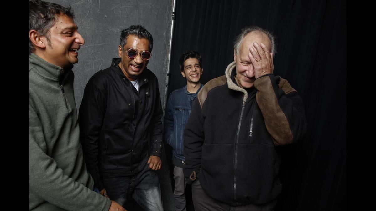 Naman Ramachandran, left, Q., and Shashank Arora with Werner Herzog.