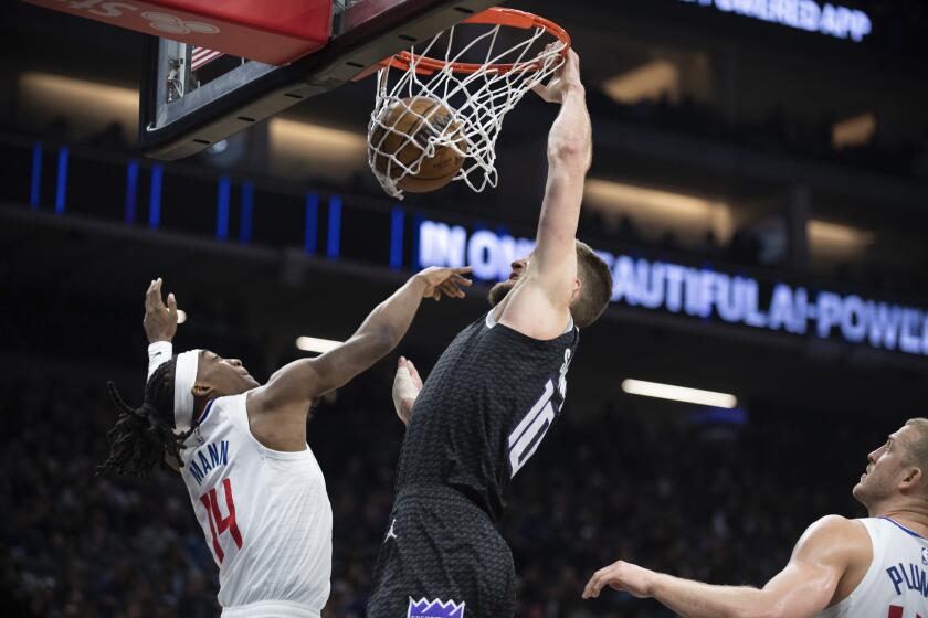 Kings forward Domantas Sabonis dunks over Clippers guard Terance Mann during the first quarter March 3, 2023.