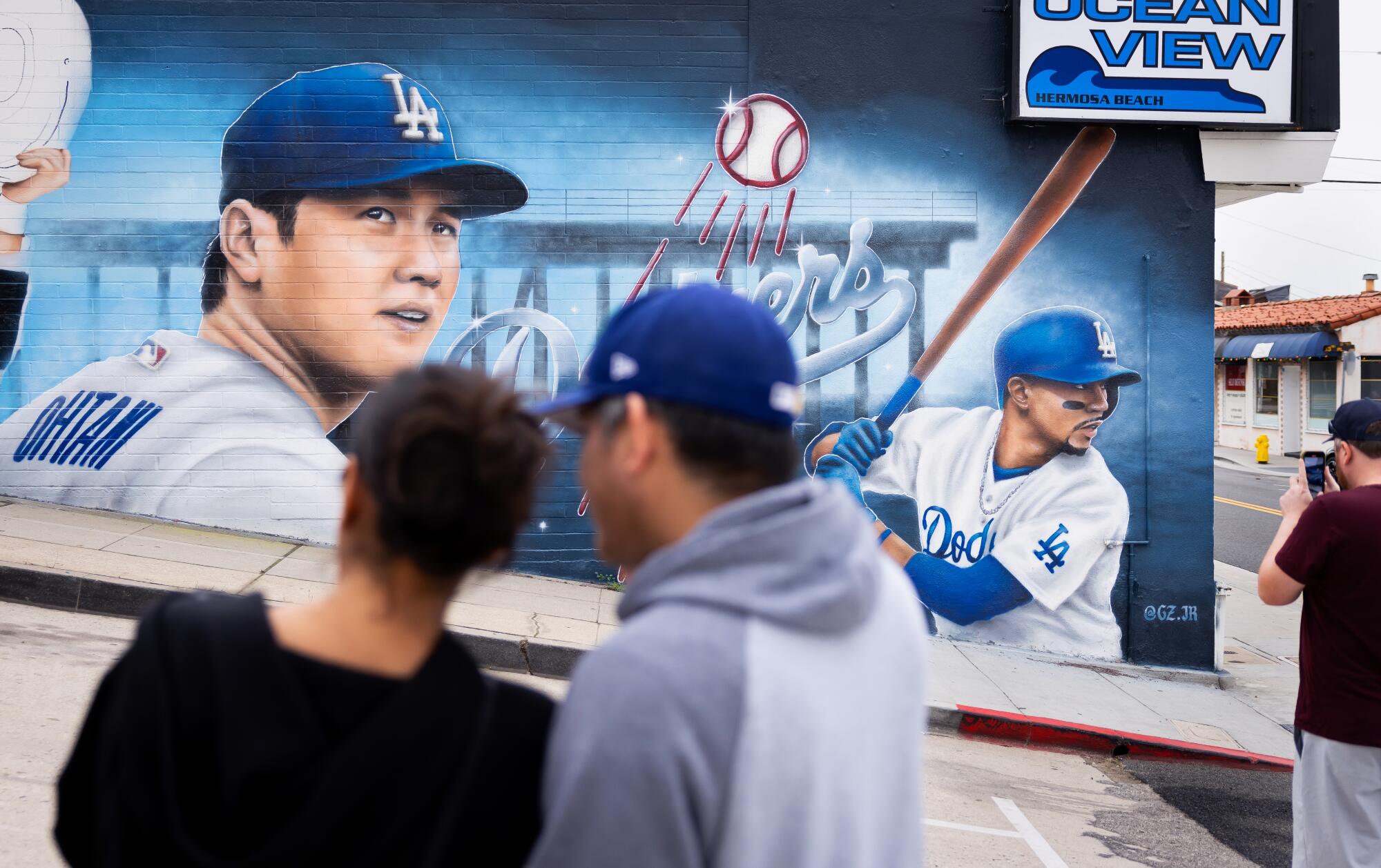 People stop to take photos of a mural featuring Dodgers Shohei Ohtani and Mookie Betts