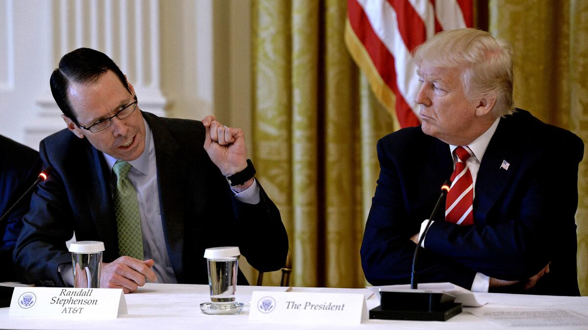 AT&T Chief Executive Randall Stephenson, left, speaks as President Trump looks on at a White House event in June 2017.
