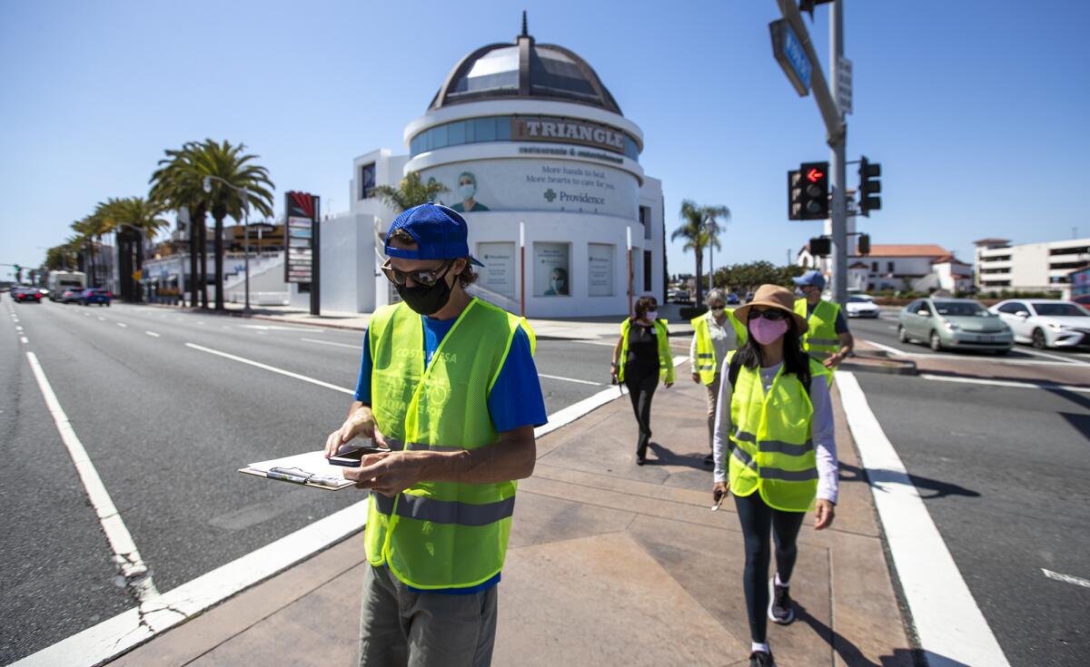 Consultants, city staff and officials cross Newport Boulevard in Costa Mesa during a walking audit.