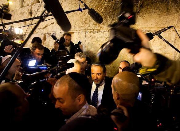 Journalists surround Avigdor Lieberman, leader of the far-right Yisrael Beitenu party, as he visits the Western Wall in Jerusalem on the eve of parliamentary elections. Israeli candidates scrambled to win over a record number of undecided voters on a day before the tight parliamentary election dominated by the meteoric rise of an ultra-nationalist party.