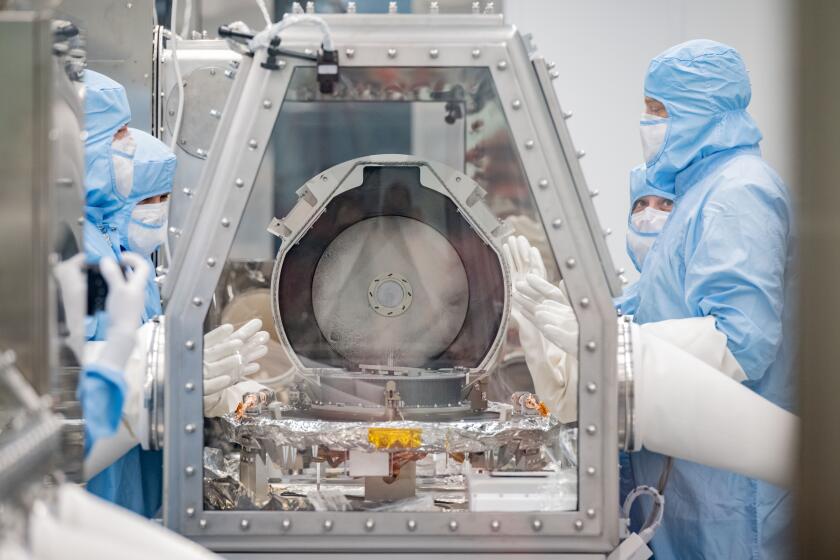 Workers at NASA’s Johnson Space Center in Houston remove the lid of the OSIRIS-REx sample return canister.