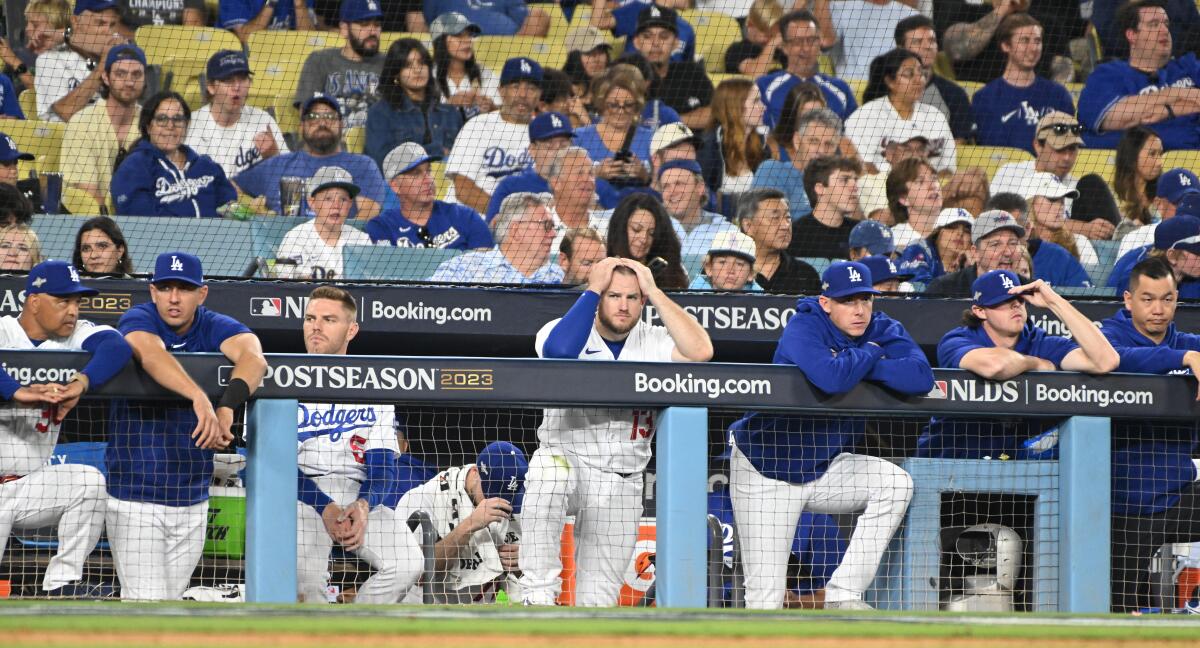 Dodgers players react in the dugout after going down 10-0 in the seventh inning Saturday.