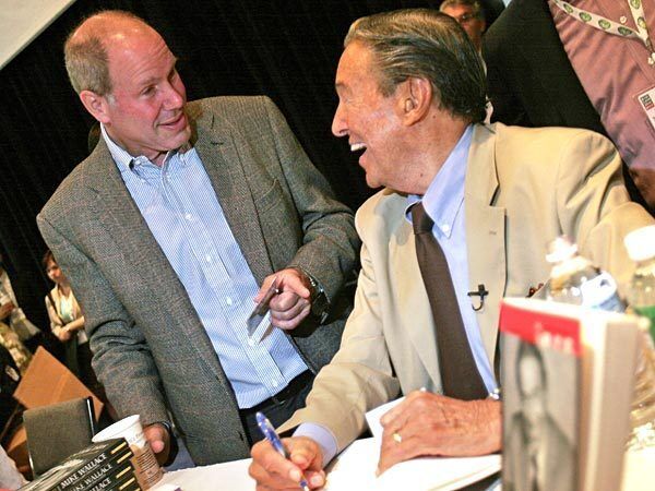 Mike Wallace, right, talks with Disney CEO Michael Eisner at the Book Expo held at the Javits Center on June 4, 2005, in New York.