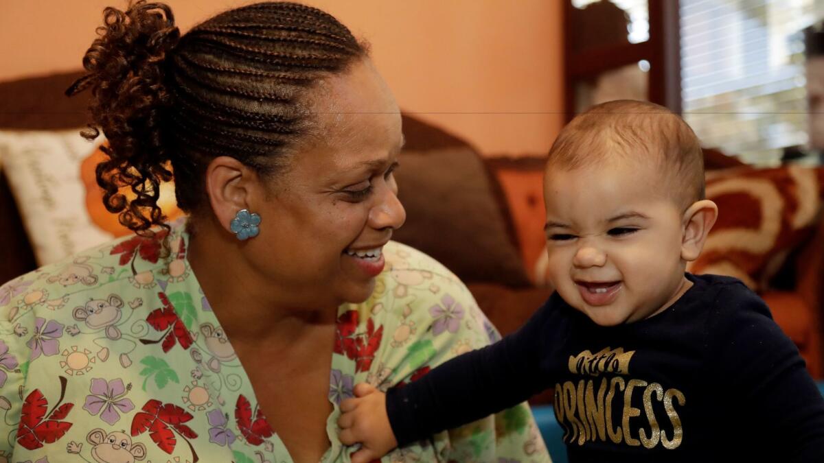 Nancy Harvey cares for a toddler at her Oakland home, which she has converted into a child care center. "I have to work and pray and hope my health continues to remain good so that I can continue to work," she says.