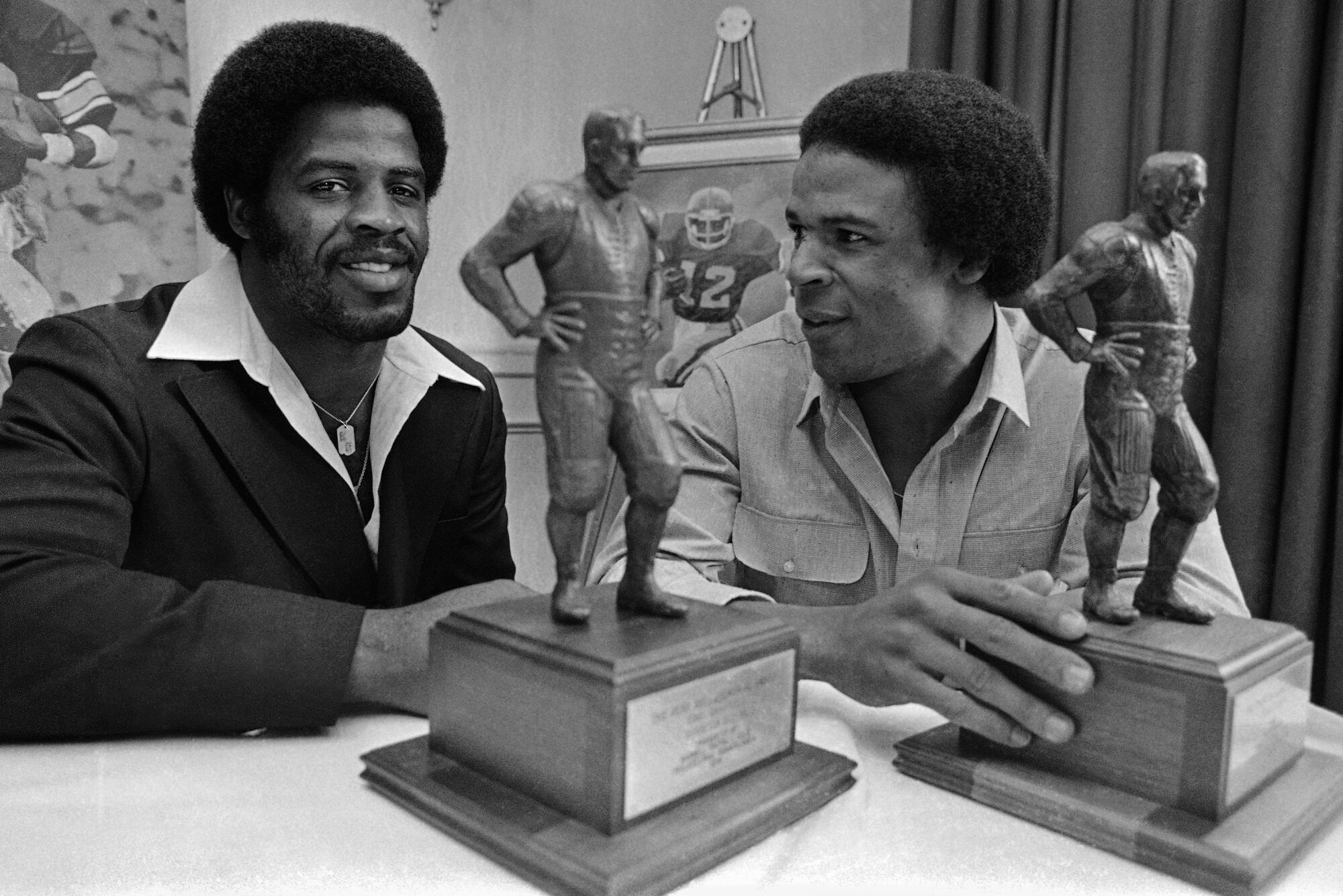 Earl Campbell of the Houston Oilers poses with USC’s Charles White on Jan. 30, 1980.