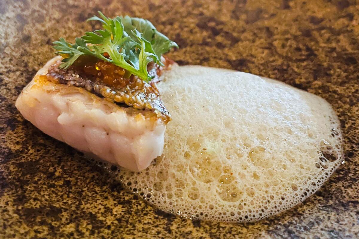 Tilefish with foam and a green leafy garnish