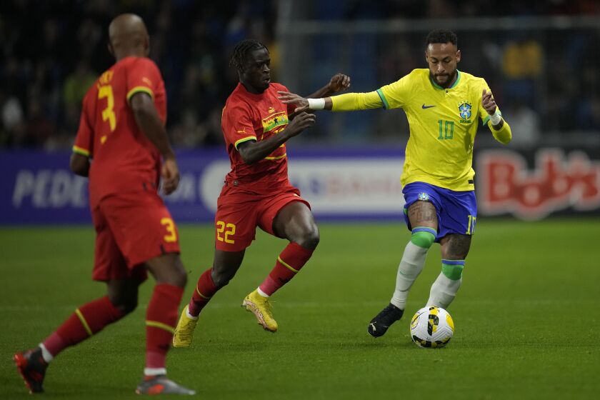 El delantero brasileño Neymar (derecha) pugna el balón con el ghanés Kamaldeen Sulemana durante un partido amistoso en Le Havre, Francia, el 23 de septiembre de 2022. (AP Foto/Christophe Ena)