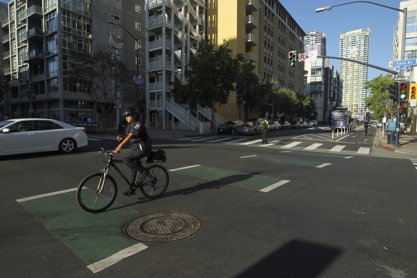A cyclist uses a bike lane while crossing Tenth Avenue on J Street in downtown on Tuesday, July 9, 2019 in San Diego, California.