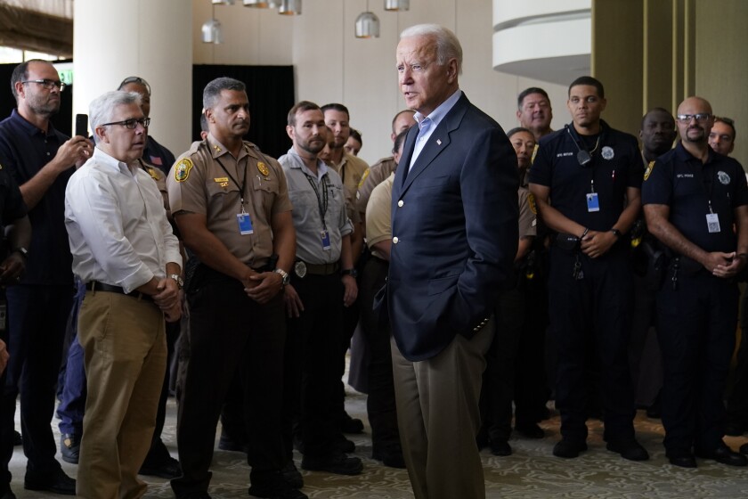 President Biden talks solemnly with a group of people.