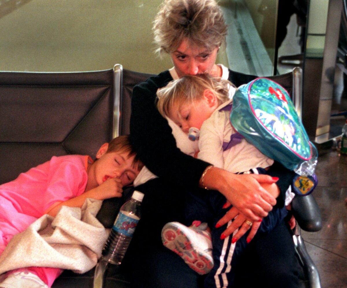 A woman and children wait for a flight at Orange County's John Wayne Airport.