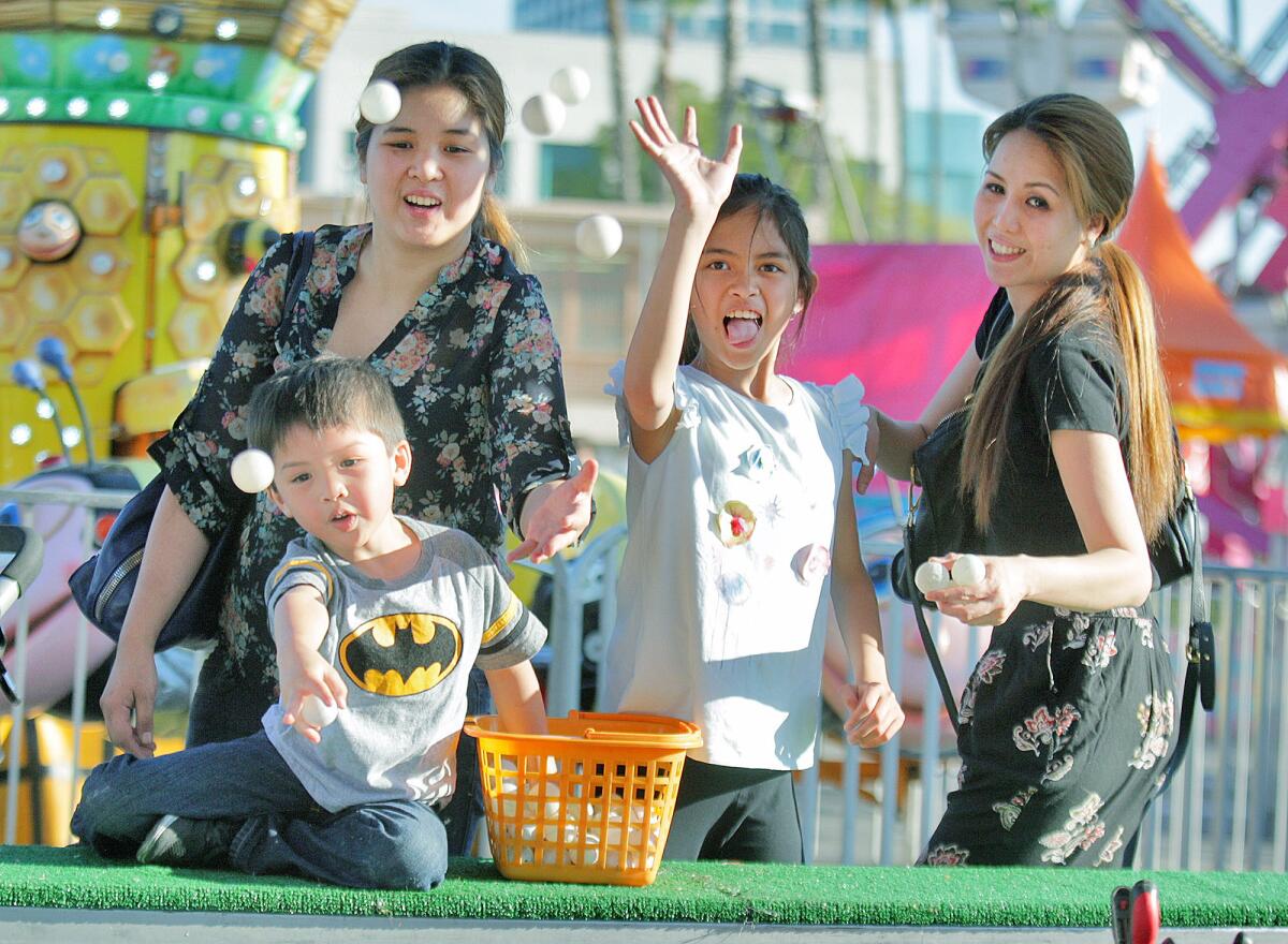 The Yutadco's, with Anna Christine, Calix, 4, Alexa, 10, Anna Charlene, all of Glendale, toss ping pong balls from a once full basket at a game at Incarnation Catholic Church in Glendale at the third annual Summer Carnival on Friday, June 17, 2016.