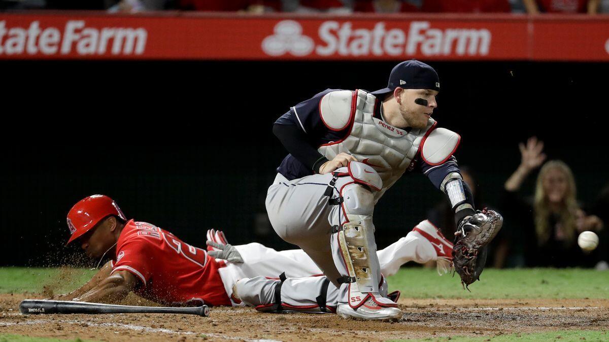 Angels' Ben Revere, left, scores past Cleveland Indians catcher Roberto Perez on a fielding error by right fielder Jay Bruce during the seventh inning on Wednesday.