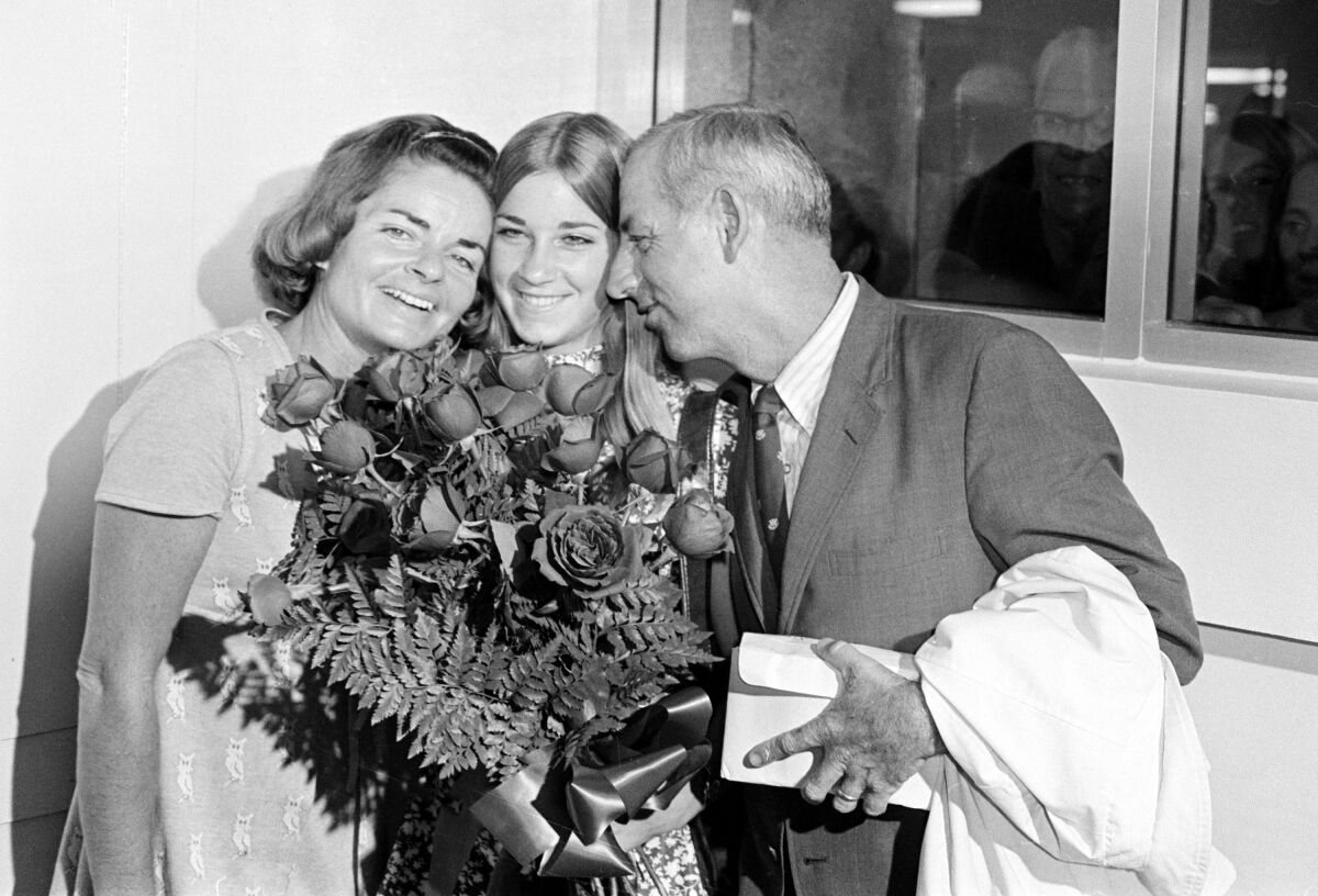 FILE - In this Sept. 12, 1971, file photo, 16-year-old tennis star Chris Evert holds a bouquet of roses given to her by the mayor as she gets a hug from her mother, Colette, and father, James, upon returning from the U.S. Open tennis tournament in New York, in Fort Lauderdale, Fla. Colette Evert, the matriarch of a tennis family that produced five children who were successful in the age-group and professional ranks, including 18-time Grand Slam champion Chris Evert, has died. She was 92. She died last Thursday, Nov. 5, 2020, in Deerfield Beach, Florida, according to a tweet by Chris Evert and an online obituary posted by Fred Hunter’s Funeral Home in Fort Lauderdale. (AP Photo/File)