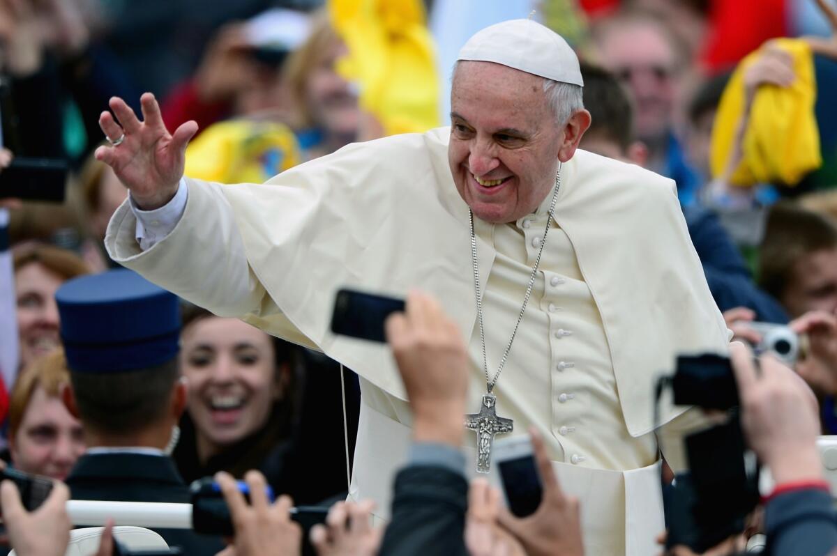 Pope Francis waves to pilgrims gathered in St. Peter's Square in Vatican City after the canonization Mass in which John Paul II and John XXIII were declared saints.