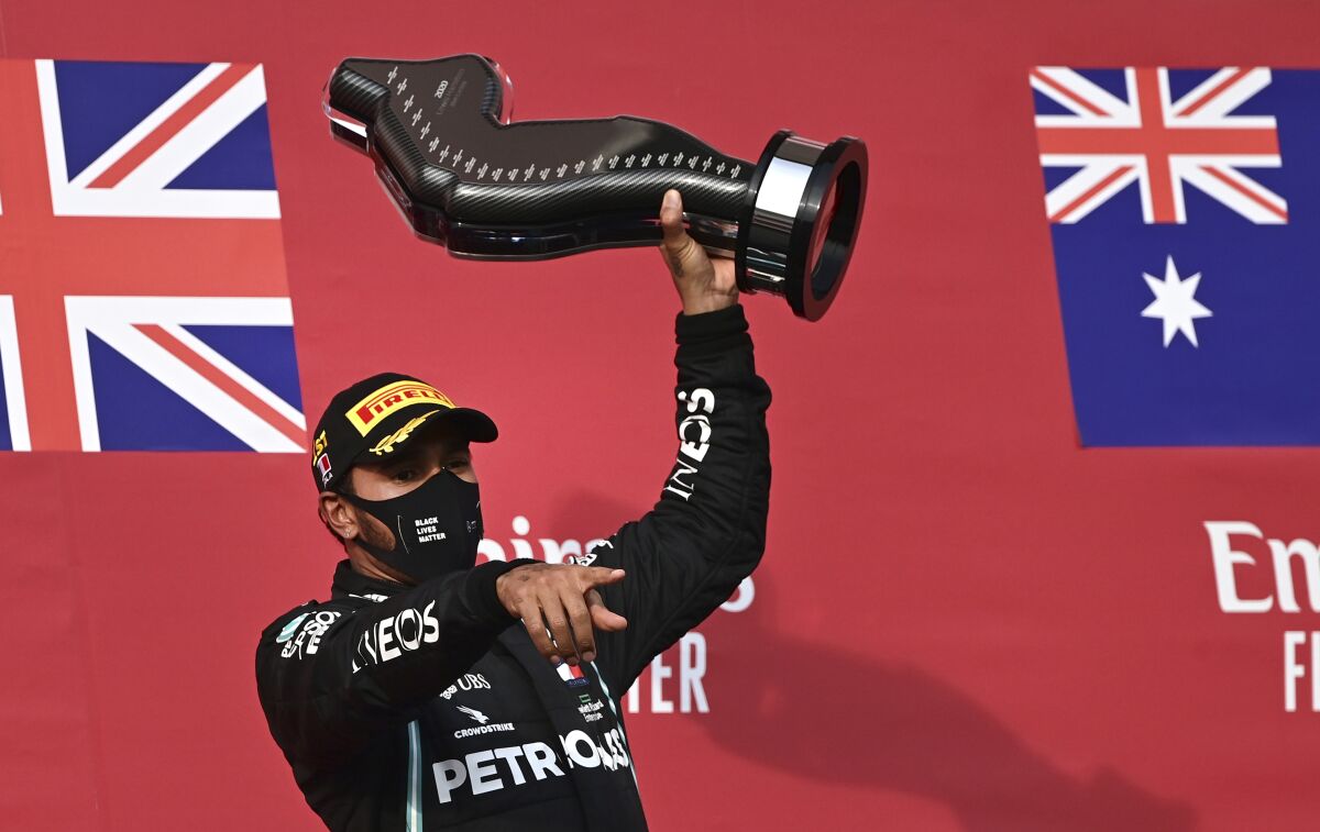 Lewis Hamilton holds up the trophy on the podium after winning the Emilia Romagna Formula One Grand Prix.