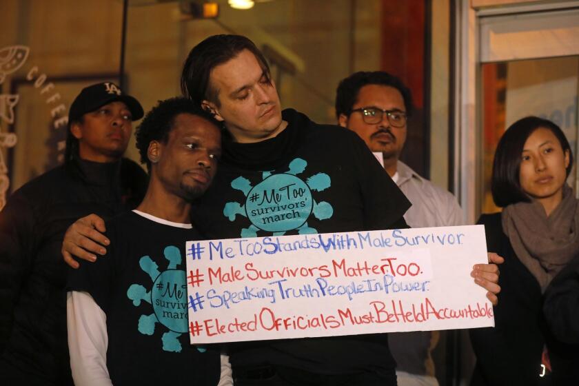 WEST HOLLYWOOD, CA - FEBRUARY 19, 2019 - - Jerome Kitchen, left, gets a hug of support from Steven Martin while joining a coalition of sexual assault survivors and LGBTQ advocacy organizations including #MeToo March International Black Lives Matter and All of Ed Buck's Victims at a rally to call on West Hollywood Mayor John Duran to resign amid new allegations of sexual harassment against Duran by members of the Gay Men's Chorus of Los Angeles outside the West Hollywood City Council chambers on February 19, 2019. (Genaro Molina/Los Angeles Times)