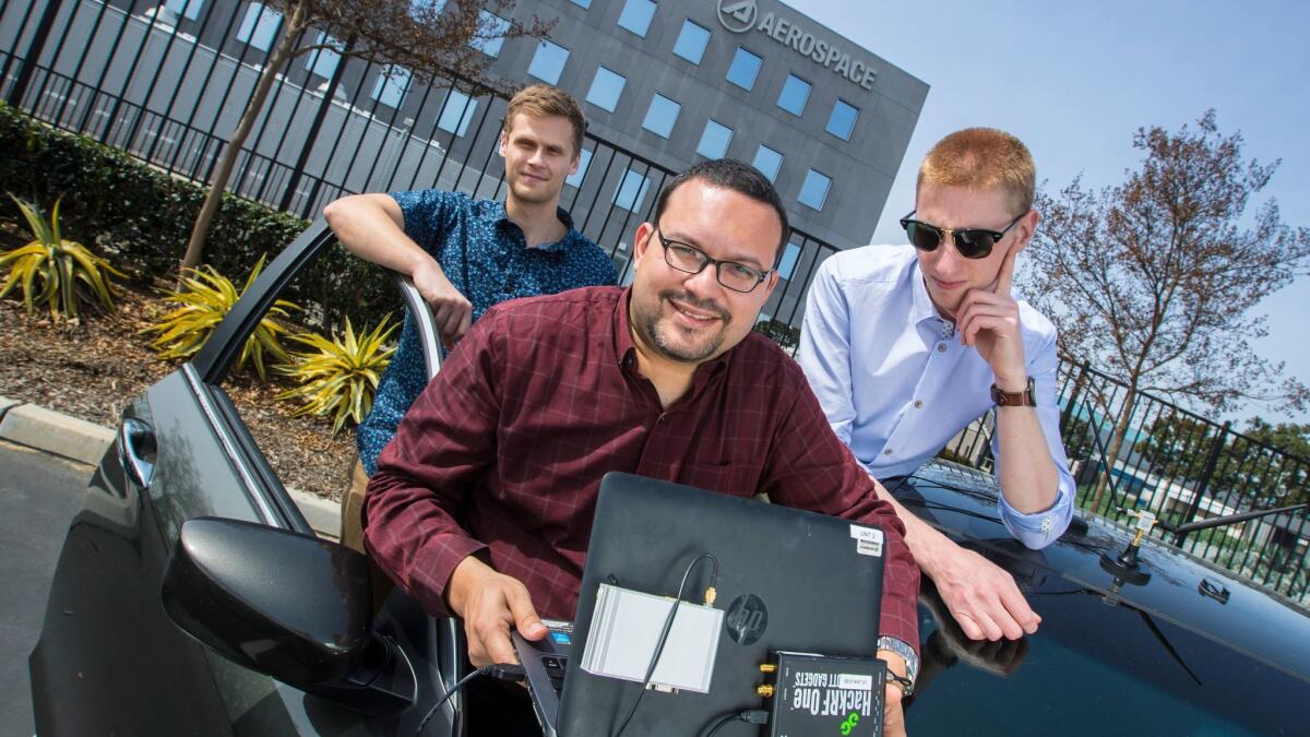Aerospace Corp. engineers from left, Sebastian Olsen, Andres Vila and Alon Krauthammer with their test car, computer and antenna they use for field testing a new GPS alternative in El Segundo on March 9, 2018.